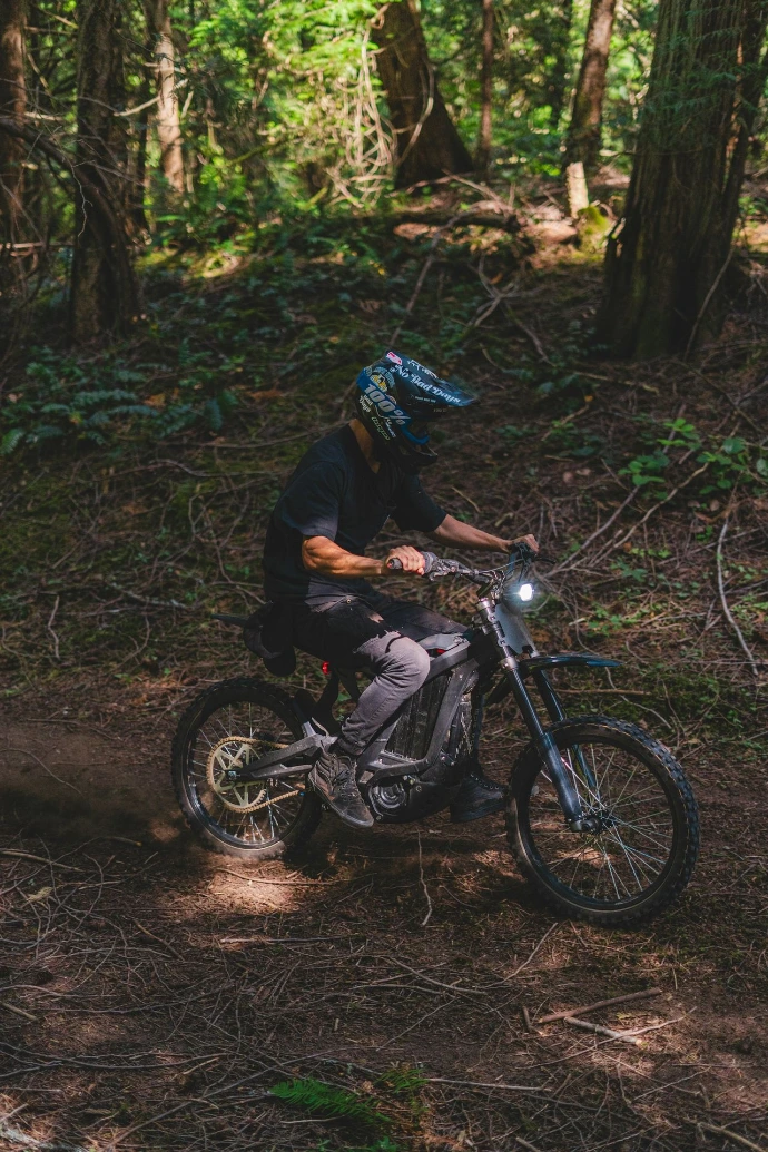 a man riding a dirt bike through a forest